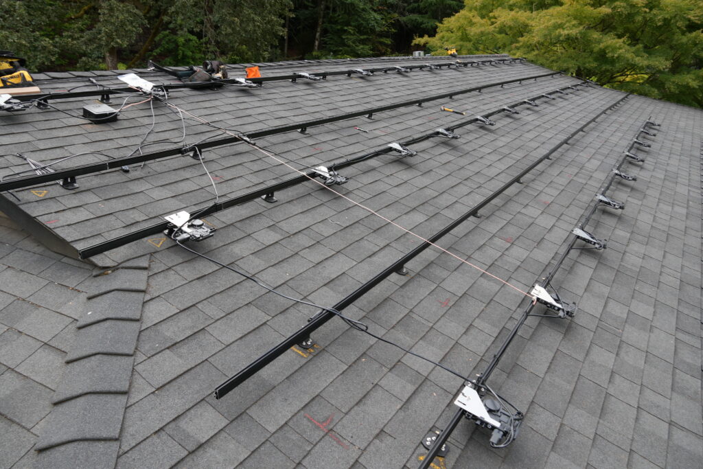 IronRidge roof racking, Enphase microinverters, and solar wiring installed before the panels are mounted.