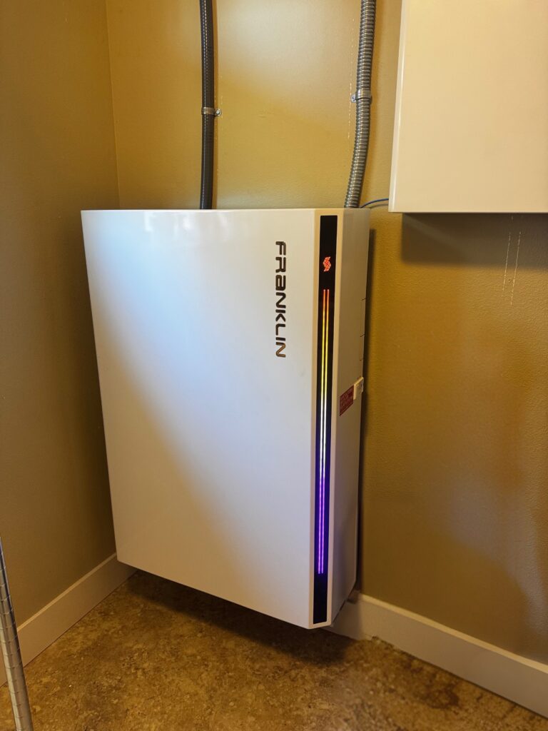 Wall-mounted FranklinWH home battery installed indoors with illuminated status lights.