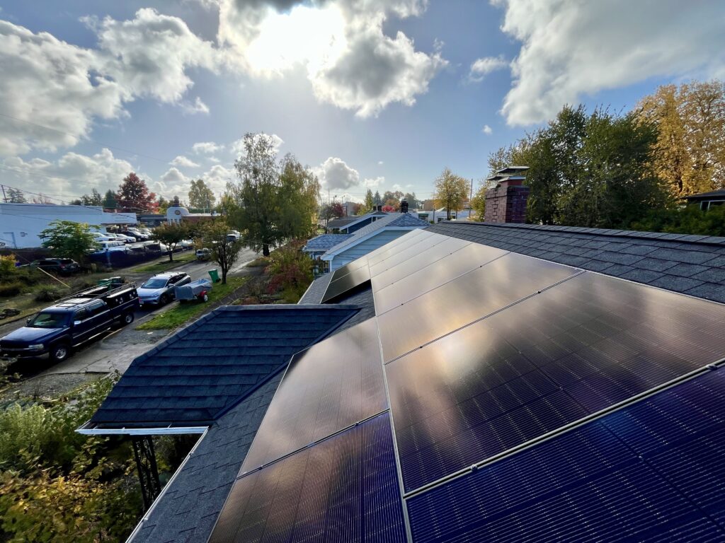 Rooftop solar panels installed on a Portland-area home under a sunny sky.