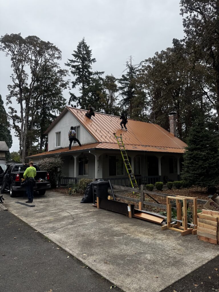 Installers prepare mounting hardware on the standing-seam metal roof of a Milwaukie home before solar panels are fitted.